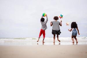 mångfald grupp av afrikansk amerikan barn spelar på en tropisk strand. etniskt olika begrepp foto