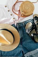 sommar kvinna kläder, Tillbehör. sandaler, denim skjorta, topp, hatt, rotting väska. skönhet blog begrepp. foto