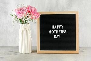 Lycklig mors dag begrepp. blommor i vas och brev styrelse med text foto