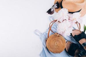 feminin sommar Tillbehör klänning, rotting väska, sugrör hatt, sandaler, pion på vit bakgrund foto