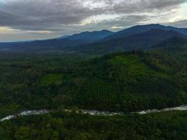 skön morgon- se av Indonesien. antenn Foto av en flod mellan de bergen och skogar av indonesien