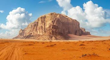 röd sandstrand och enorm sten i de mitten, wadi rom öken, jordan foto