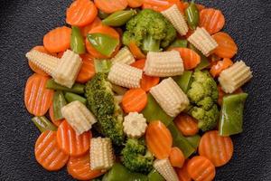 en blandning av grönsaker morötter, små huvuden av majs, sparris bönor ångad foto