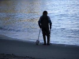 man sökande med metall detektor på de strand foto