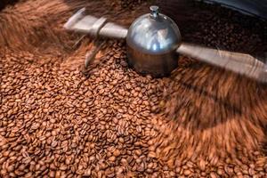 rostad spinning kylare professionell maskiner och färsk brun kaffe bönor rörelse stänga upp mörk Foto på fabrik, rörelse fläck effekt. närbild av färsk brun kaffe utsäde rostning