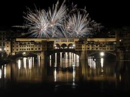 brand Arbetar fyrverkeri på ponte vecchio bro florens på natt foto