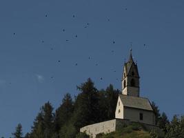 la valle små kyrka med många ravens i dolomiter foto