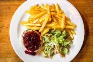 grillad hermelin ost med vegetabiliska sallad och bränder på tallrik foto