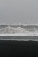 stor skummig Vinka på bukt strand svartvit landskap Foto