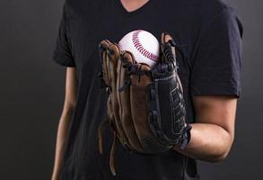 asiatisk manlig modell med baseboll handske isolerat på mörk bakgrund. baseboll spelare begrepp foto