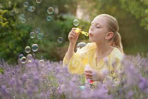 skön liten flicka i en fält med lavendel. foto