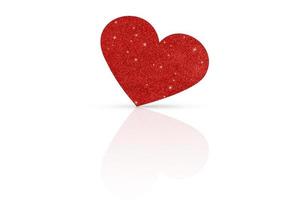 ett glittrande röd hjärta på en vit glansig bakgrund. hjärtans dag foto