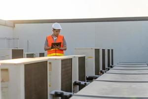 fabrik ingenjörer gående och kontroll de kyl- systemet av de fabrik. främre del man uppgifter de tillstånd av de kompressor innan underhåll enligt underhåll planen. foto