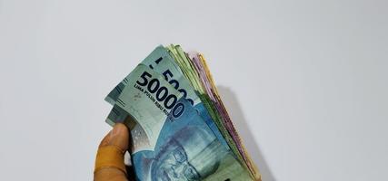 olika färger och valörer av indonesiska rupiah valuta i hand isolerat vit bakgrund foto