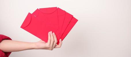 kvinna innehav kinesisk röd kuvert, pengar gåva för Lycklig lunar ny år Semester foto