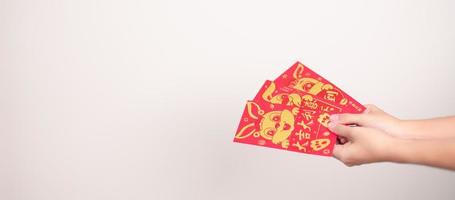 kvinna innehav kinesisk röd kuvert med gyllene kanin och välsignelse ord, pengar gåva för Lycklig lunar ny år Semester. kinesisk mening betyder lycka, friska, tur- och rik foto