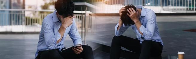 ung affärsman gråt övergivna förlorad i depression sitter på markgatan betong trappor lidande känslomässig smärta, sorg, ser sjuk i grungeljus foto