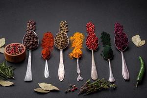 flera typer av kryddor i metall skedar paprika, tomater, curry, rödbetor, kummin, gurkmeja, fänkål, spirulina foto