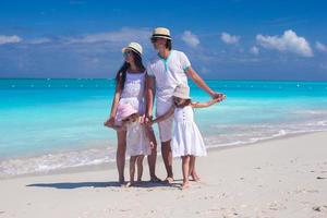 familj på fyra på en vit strand foto