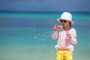 flicka som har kul att blåsa bubblor på stranden foto
