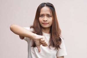 asiatisk kvinnas hand höjning tummen som en tecken av motvilja foto