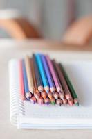 färgglada staplade pennor på en anteckningsbok foto