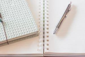 penna och anteckningsbok med en spiralanteckningsbok foto