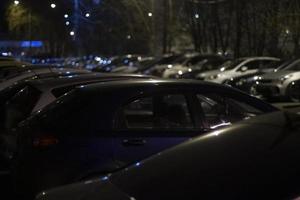 bilar på natt i parkering massa. transport i mörk. bilar stå i rad i gata ljus. foto