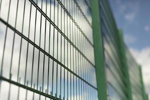 grön staket. stål maska på sporter fält. foto
