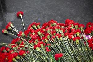 blommor på minnesmärke. detaljer av begravning dekoration. bukett av blommor på grav. foto