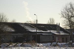 industriell byggnad i vinter. tak i snö. se av fjäderfän odla. foto