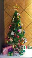 jul träd med dekoration och låda av närvarande i de hörn av de rum. foto