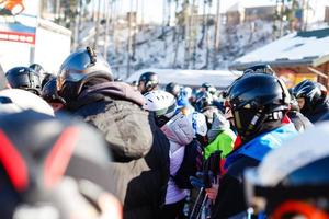 människor på åka skidor hiss, linje av skidåkare och snowboardåkare foto