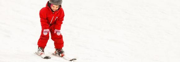 professionell åka skidor instruktör är undervisning en barn till åka skidor på en solig dag på en berg backe tillflykt med Sol och snö. familj och barn aktiva semester. foto