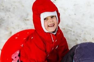 liten flicka i röd skrattande, vintertid foto