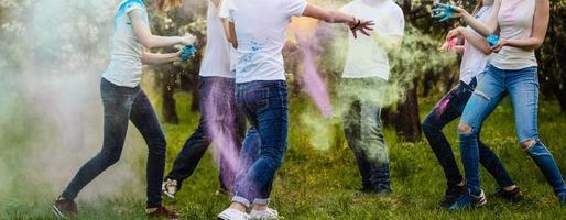 glad ung multietnisk vänner med färgrik måla på kläder och kroppar har roligt tillsammans på holi festival foto