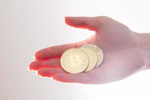 hand innehar tre mynt av digital valuta bitcoin foto