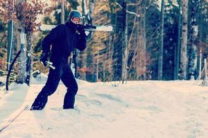 skidåkare redo innehav skidåkning Utrustning med Sol tillbaka ljus på åka skidor backe - ung idrottare i snö bergen för vinter- semester - sport begrepp och högtider begrepp - fokus på hans ansikte - värma filtrera foto