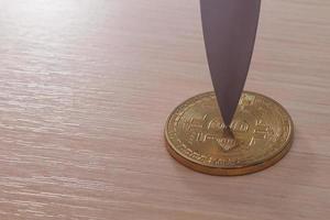 blad av en kniv på en guld mynt bitcoin foto