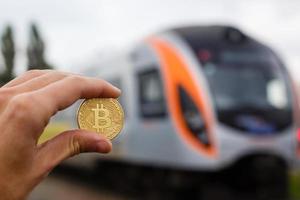 hand innehav gyllene bitcoin virtuell pengar tåg foto