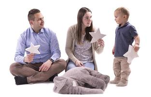 familj i de studio har roligt isolerat på vit bakgrund. pappa, mamma och två barn kram och leende foto