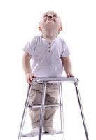 liten pojke klättrar till en stege stol. de början av en karriär begrepp. rolig liten pojke isolerat på vit bakgrund. foto