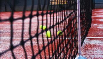 tennis racketar med tennis bollar på lera domstol foto