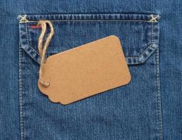 tömma brun papper märka på en rep bunden till blå jeans foto