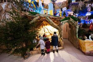 tillbaka av tre barn ser i jul nativity spjälsäng scen i kyrka. foto