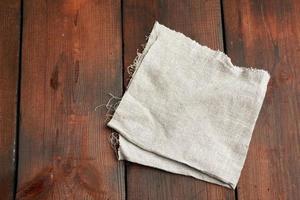 grå kök textil- handduk vikta på en brun trä- tabell från gammal brädor, topp se foto