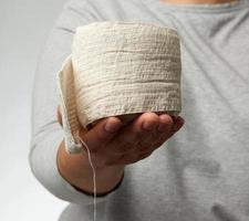 kvinna innehar i hand en vit elastisk bandage för de kropp foto