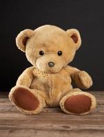 brun teddy Björn sitter på en trä- tabell foto