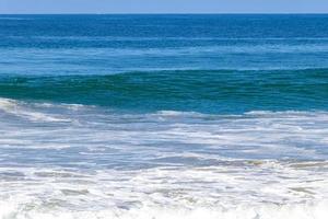 ytterst enorm stor surfare vågor på strand puerto escondido Mexiko. foto