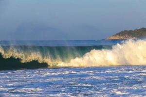 ytterst enorm stor surfare vågor på strand puerto escondido Mexiko. foto